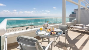 A balcony with a table set for breakfast overlooking a beach. - The Palms Hotel & Spa (Miami Beach)