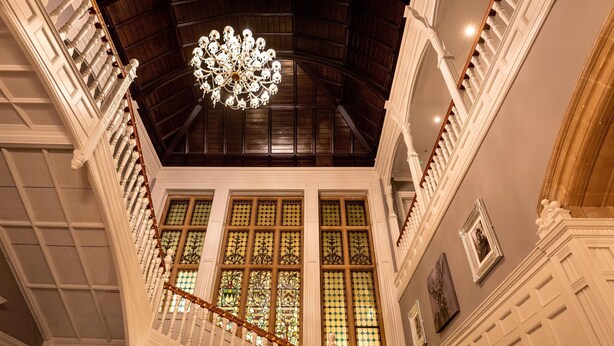 Un intérieur somptueux, avec un plafond haut, des lustres richement décorés et des vitraux.