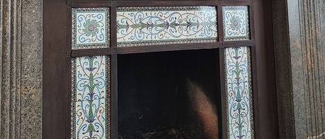 A fireplace with decorative tiles, a dark wooden mantel, and a large mirror above it.