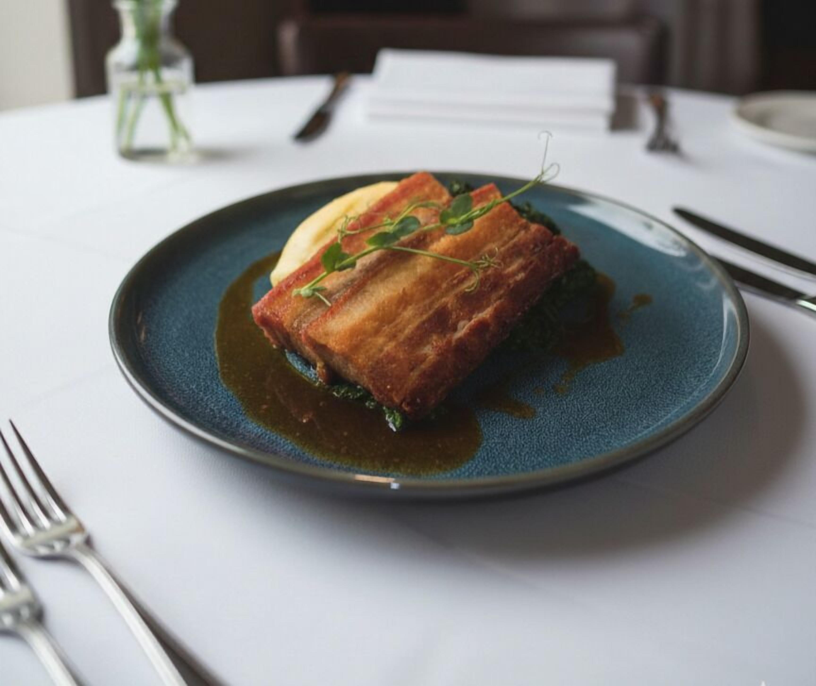 A plate with a piece of food, possibly a pastry, on a blue plate.
