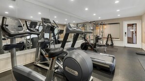 A gym with various exercise equipment, including treadmills and elliptical machines.