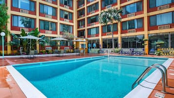 Relax by the pool surrounded by comfortable lounge chairs and umbrellas.