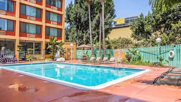 Relax by the pool surrounded by lush greenery and lounge under the shade of umbrellas.