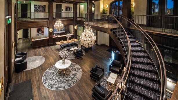 A spacious, multi-level interior with a grand staircase, elegant chandeliers, and a luxurious seating area.