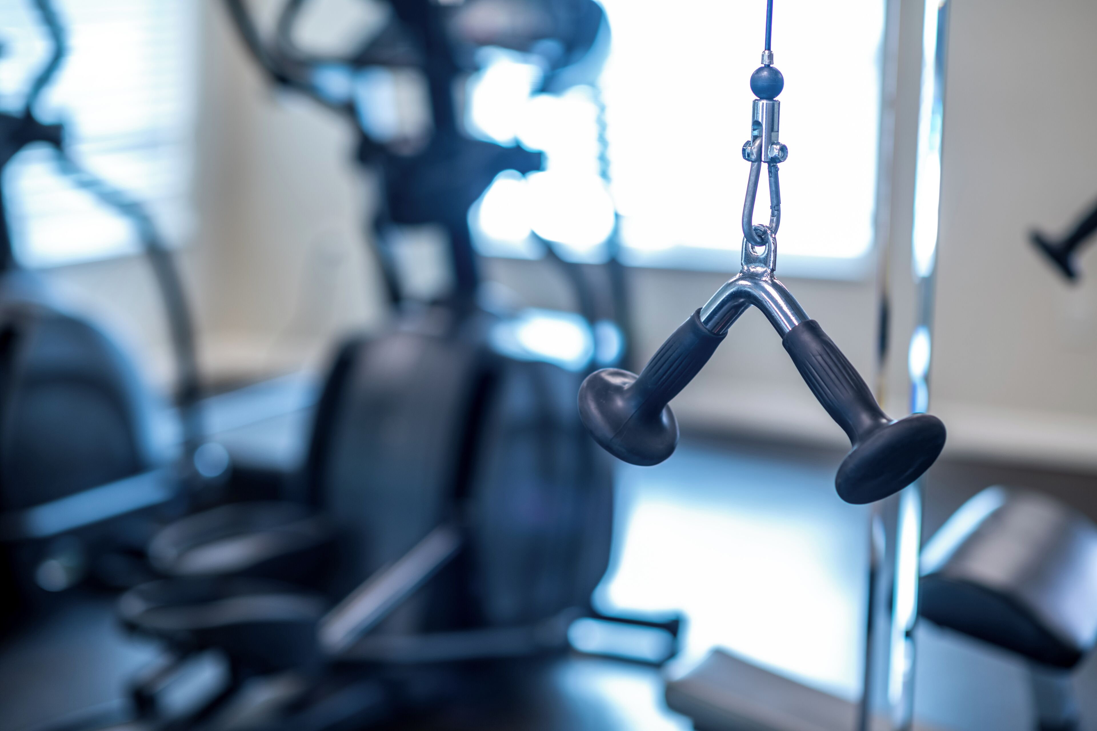 Une salle de sport équipée de matériel d'exercice, notamment une machine à câbles et des poids.