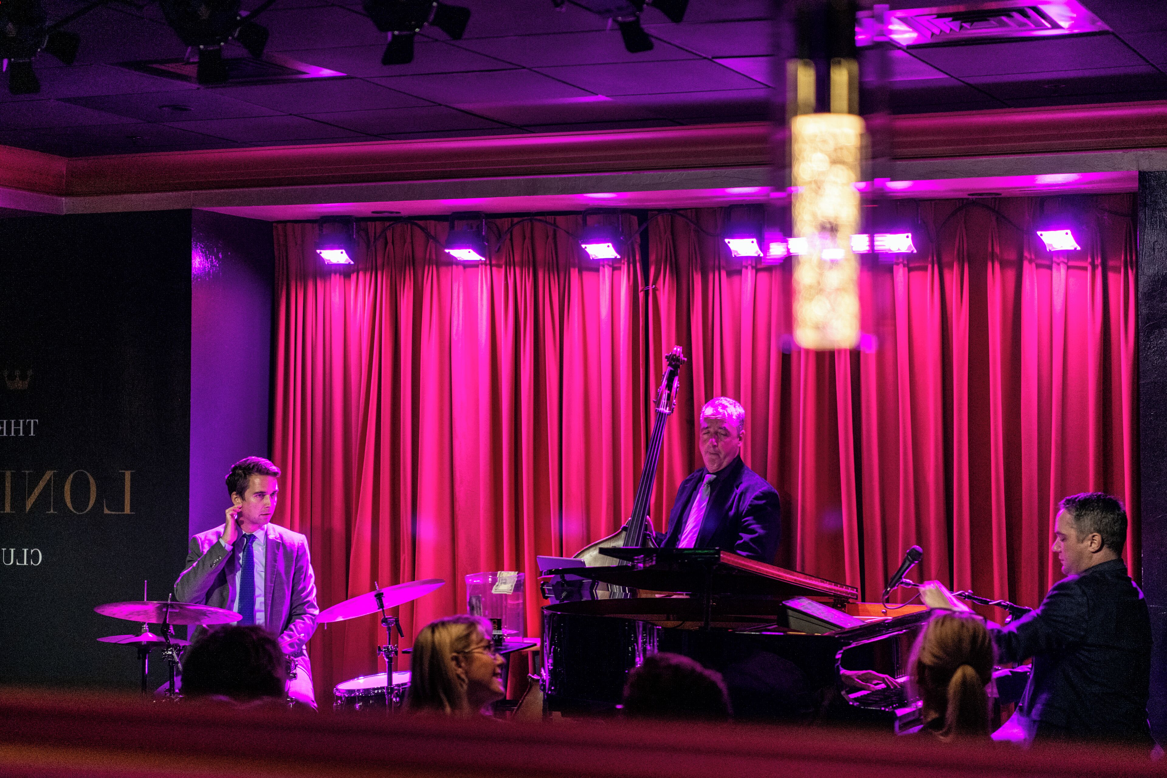 A stage with a piano, a microphone, and a person playing the piano.