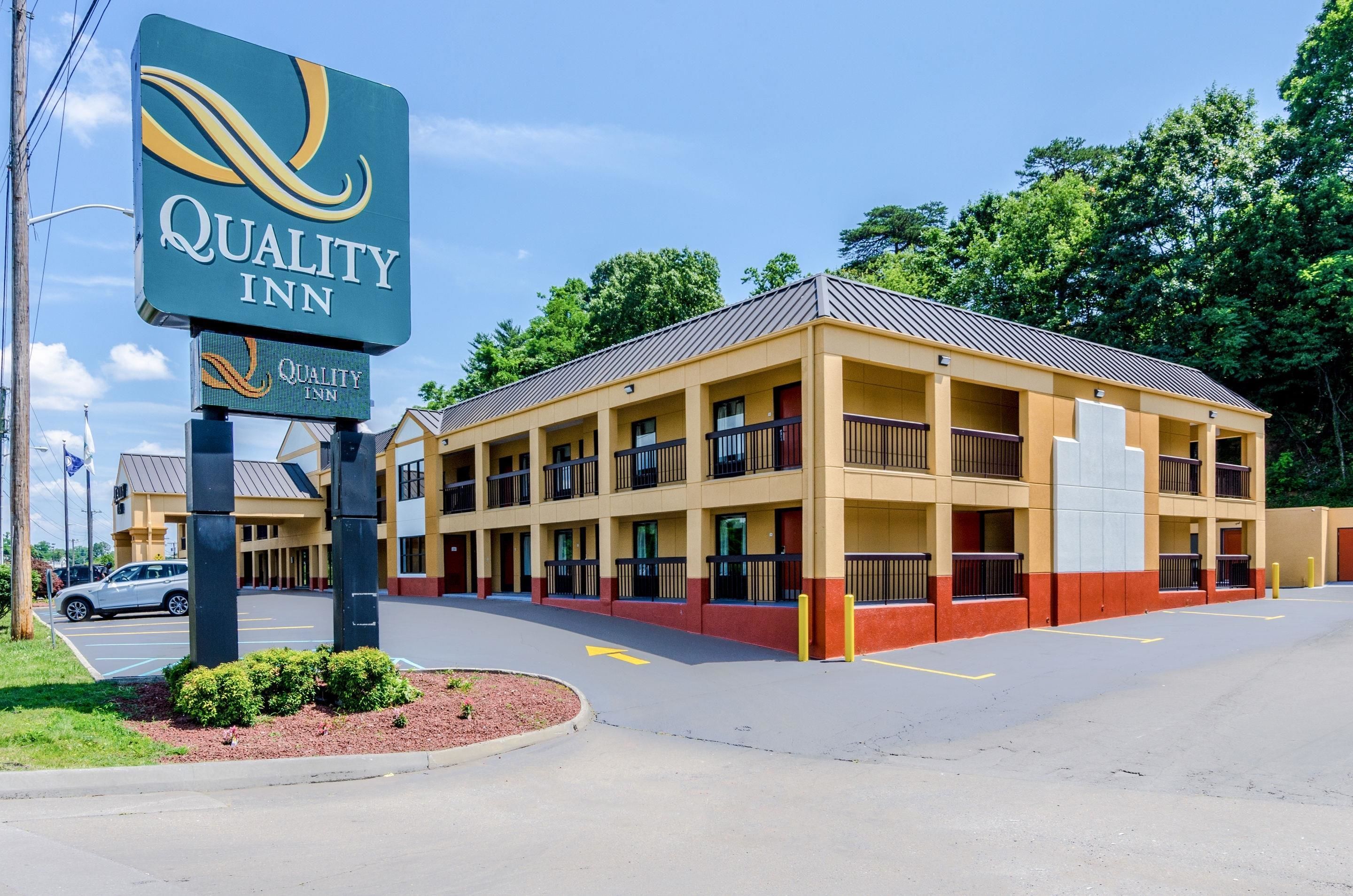Un hotel Quality Inn con un grande cartello, diversi balconi e un parcheggio.