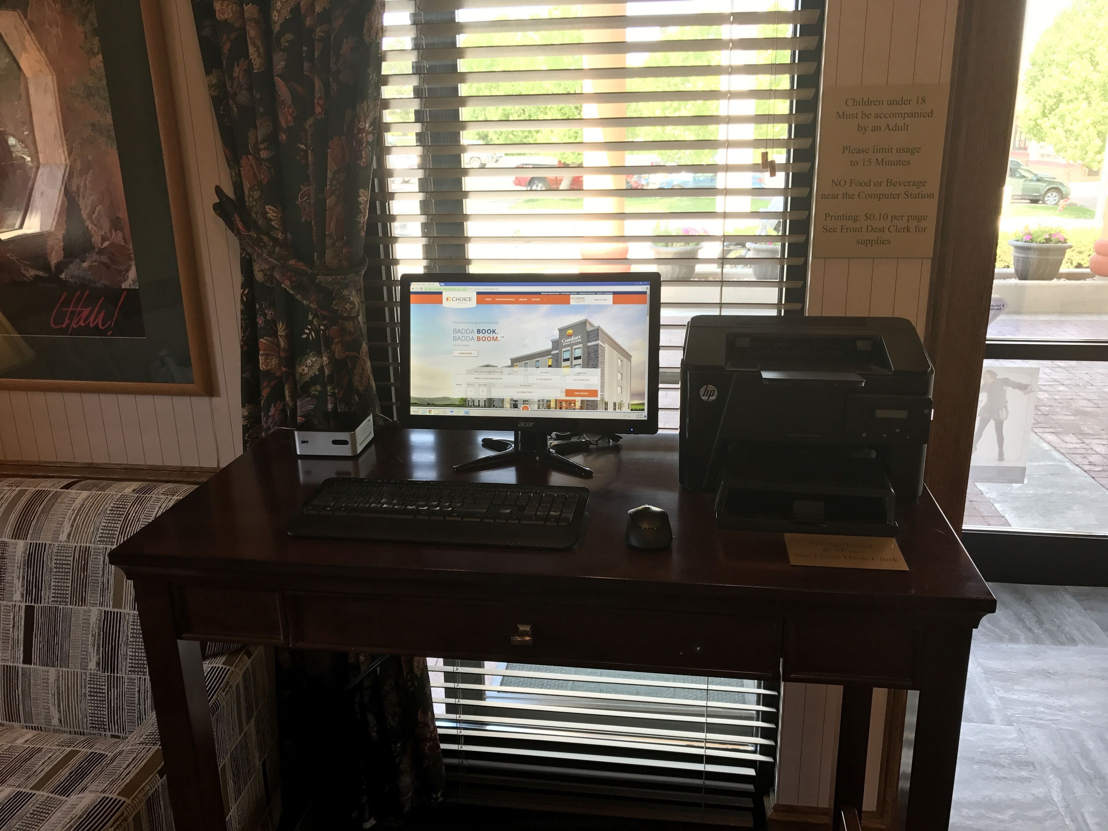 Ein Computertisch mit Monitor, Tastatur, Maus und HP-Drucker.