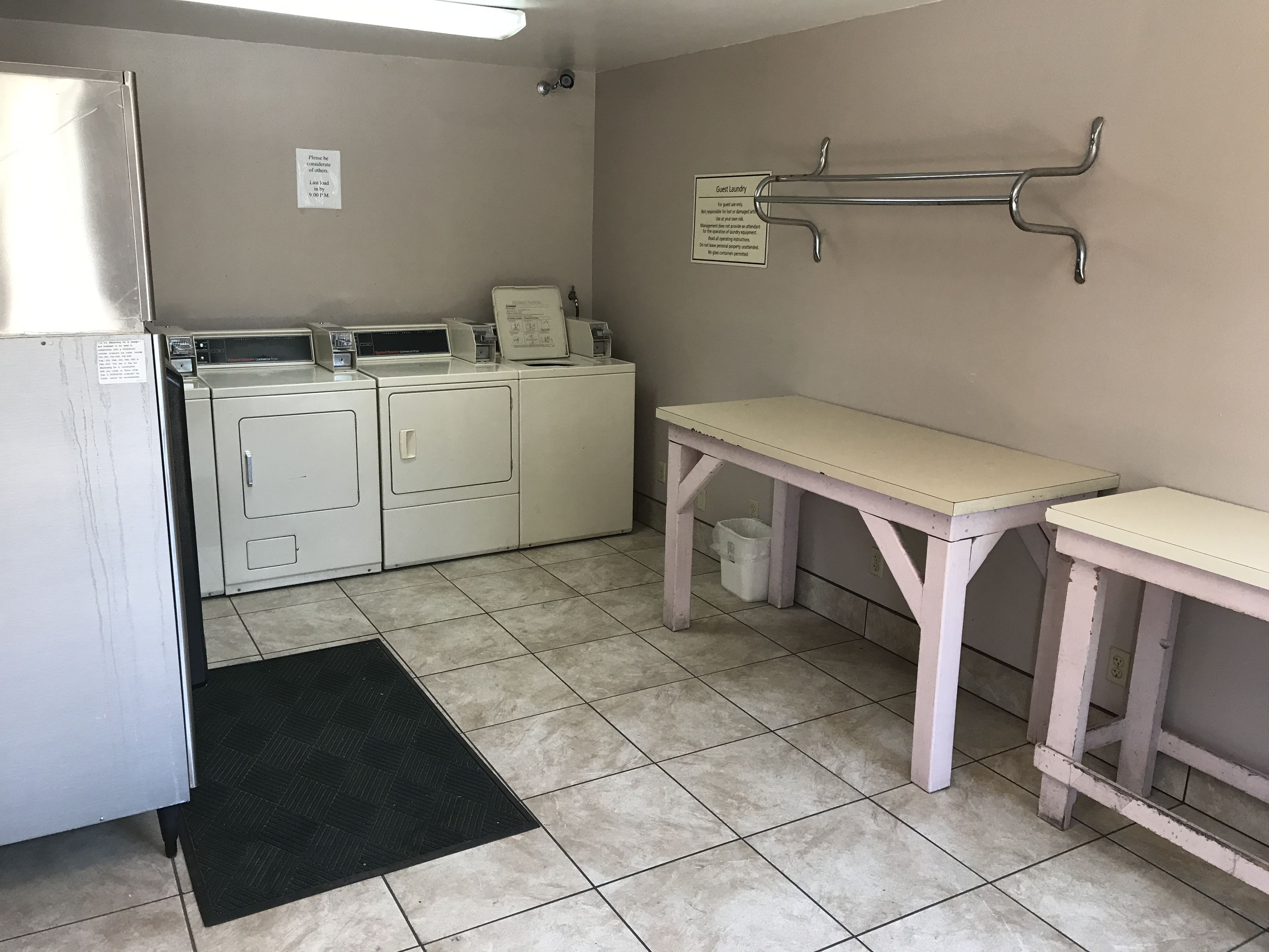 A laundry area with a washing machine, dryer, and a bench.
