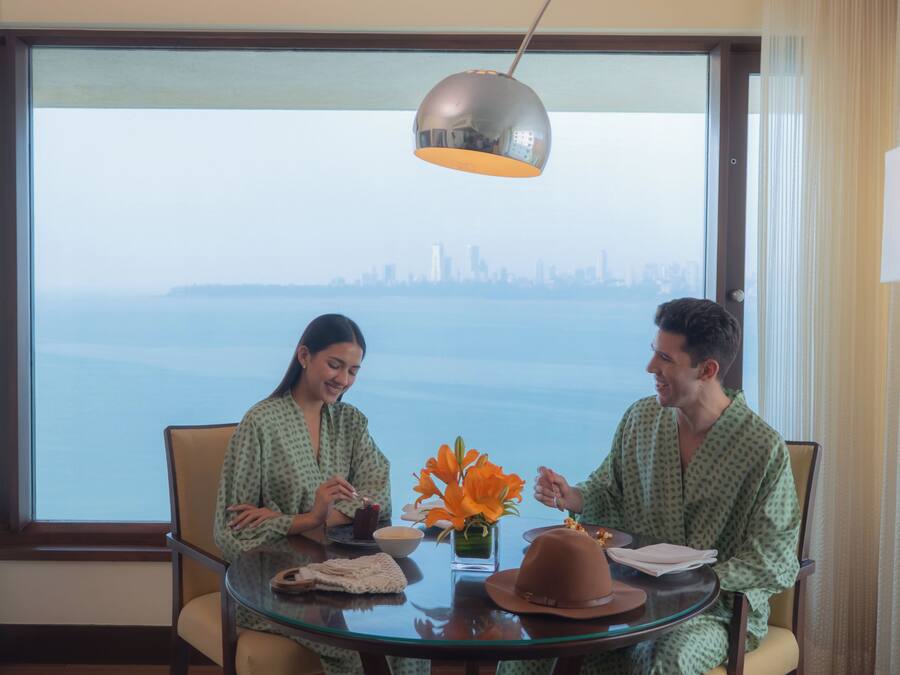 A room with a large window, a glass table, and two chairs.