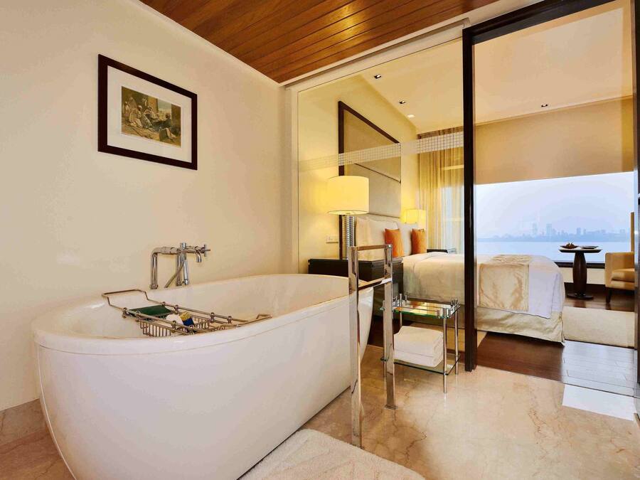 Een moderne badkamer met een vrijstaand bad, een douchecabine met glazen wanden en een grote spiegel.