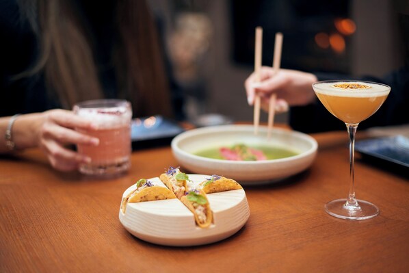 A dining table with a plate of tacos, a bowl of soup, and a cocktail glass. - Four Seasons Hotel des Bergues Geneva (Geneva)