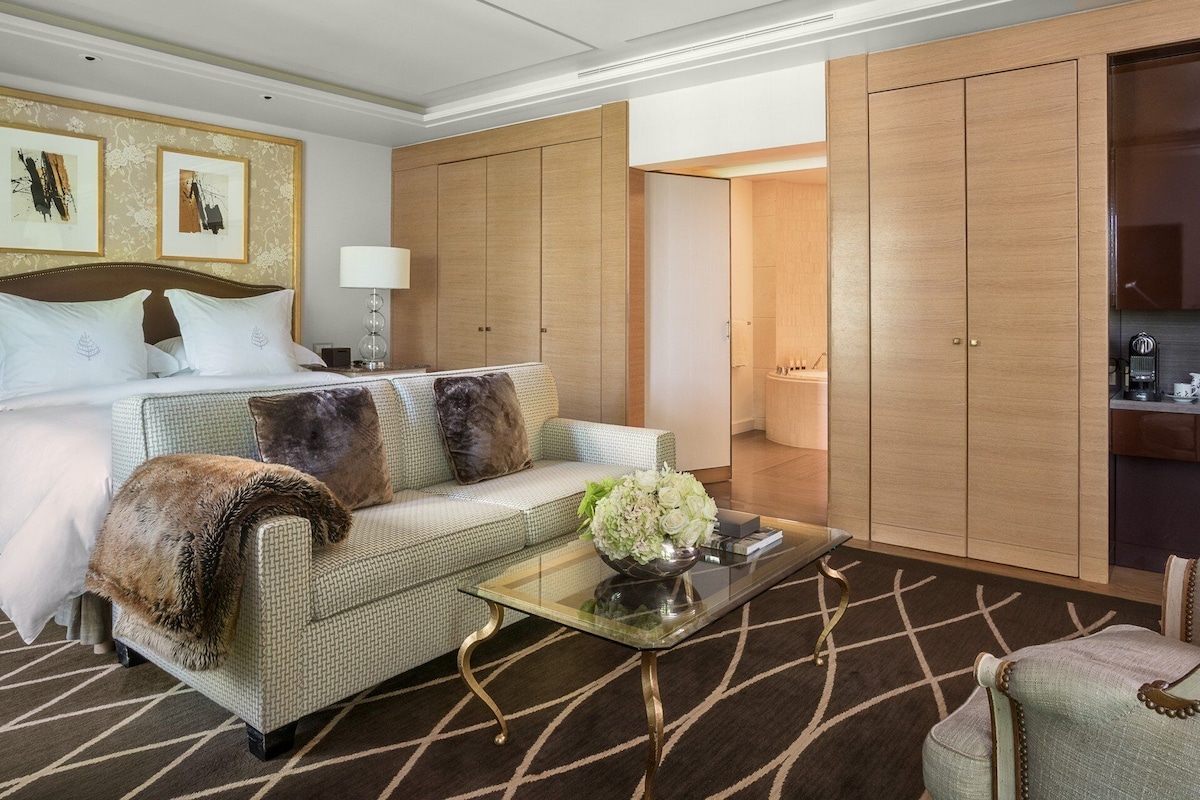Une chambre d’hôtel comprenant un lit, un canapé, une table basse et une armoire.