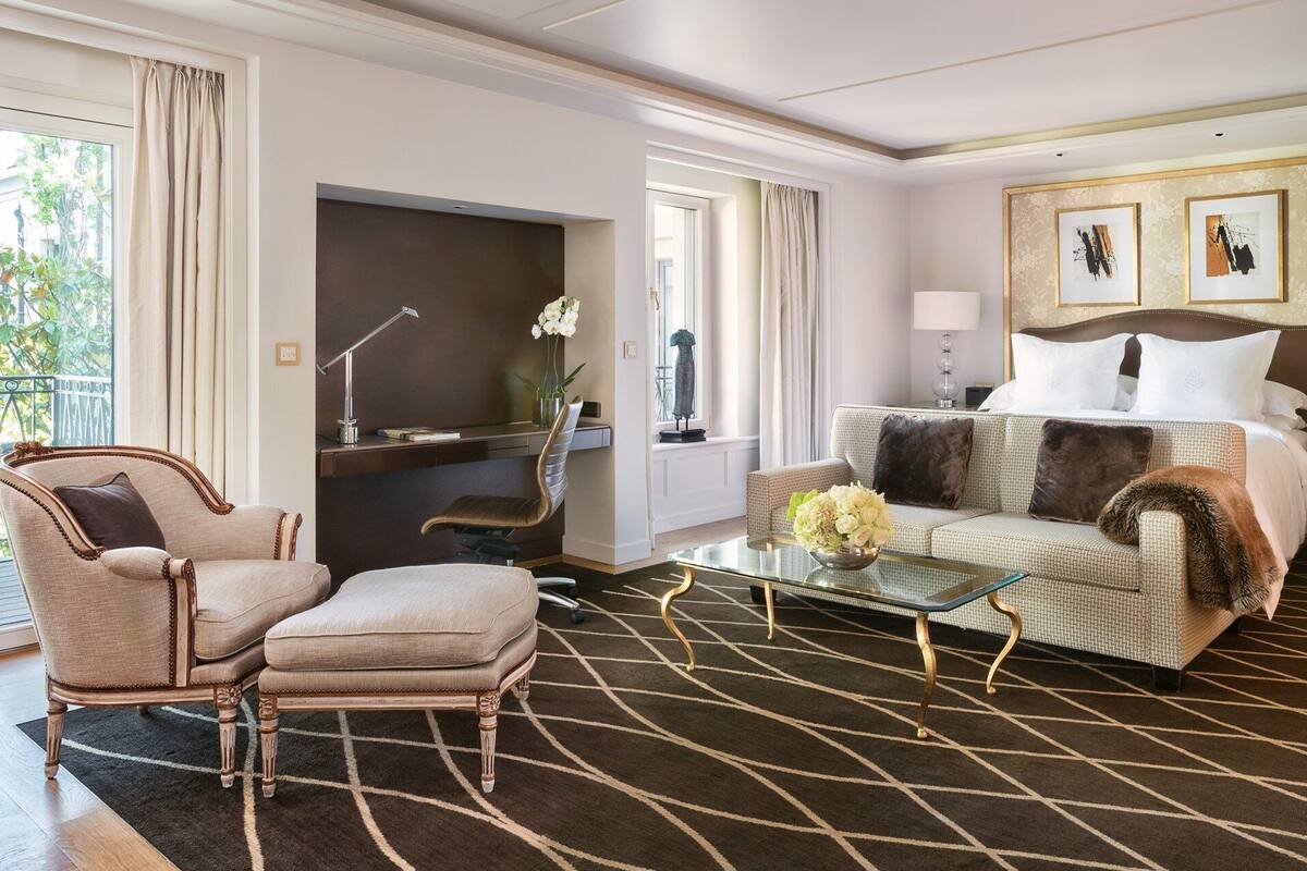 Une chambre d’hôtel comprenant un lit, un canapé, une chaise, un bureau et une table basse.