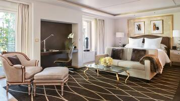 Una habitación de hotel con cama, sofá, sillón, escritorio y mesa de centro.