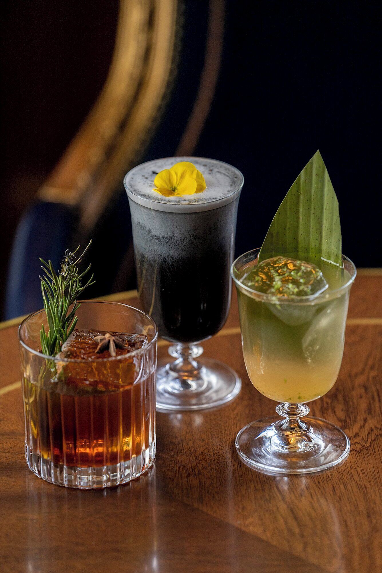 Três bebidas diferentes sobre uma mesa de madeira.