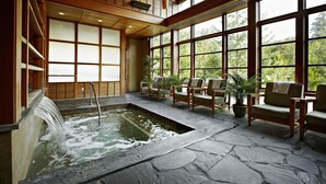 A spa area with a hot spring, wooden seating, and large windows offering a view of trees. - Salish Lodge & Spa (Fall City)