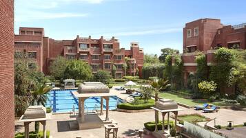 Relax by the central pool surrounded by lush greenery and palm trees in our serene courtyard.
