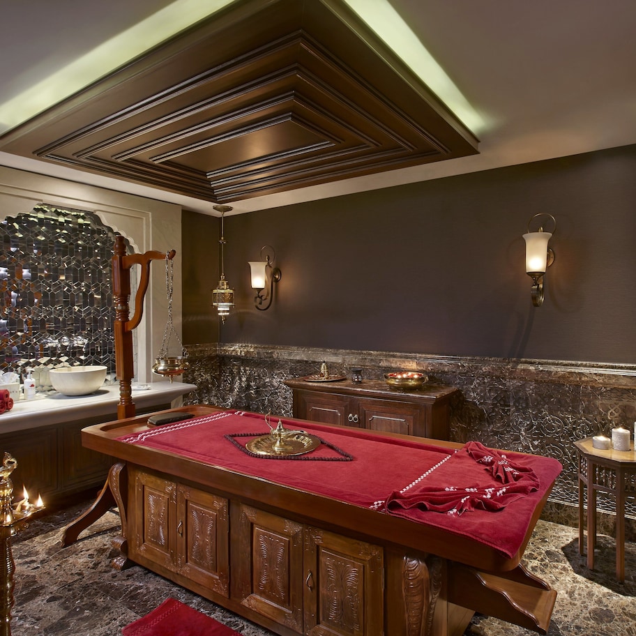 A room with a pool table, a mirror, and a decorative wall with a mosaic pattern.