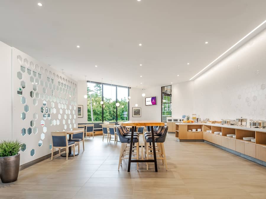 A modern dining area with hexagonal wall decor, a wooden table, and chairs.