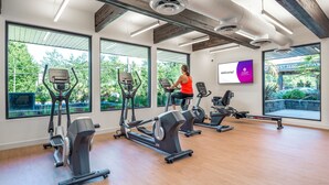 A gym with cardio machines, large windows, and a motivational poster. - Coast Tsawwassen Inn (Delta)