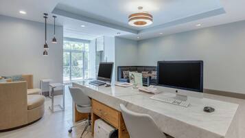Un espacio de oficina moderno con dos escritorios, computadoras y una zona de estar cómoda.