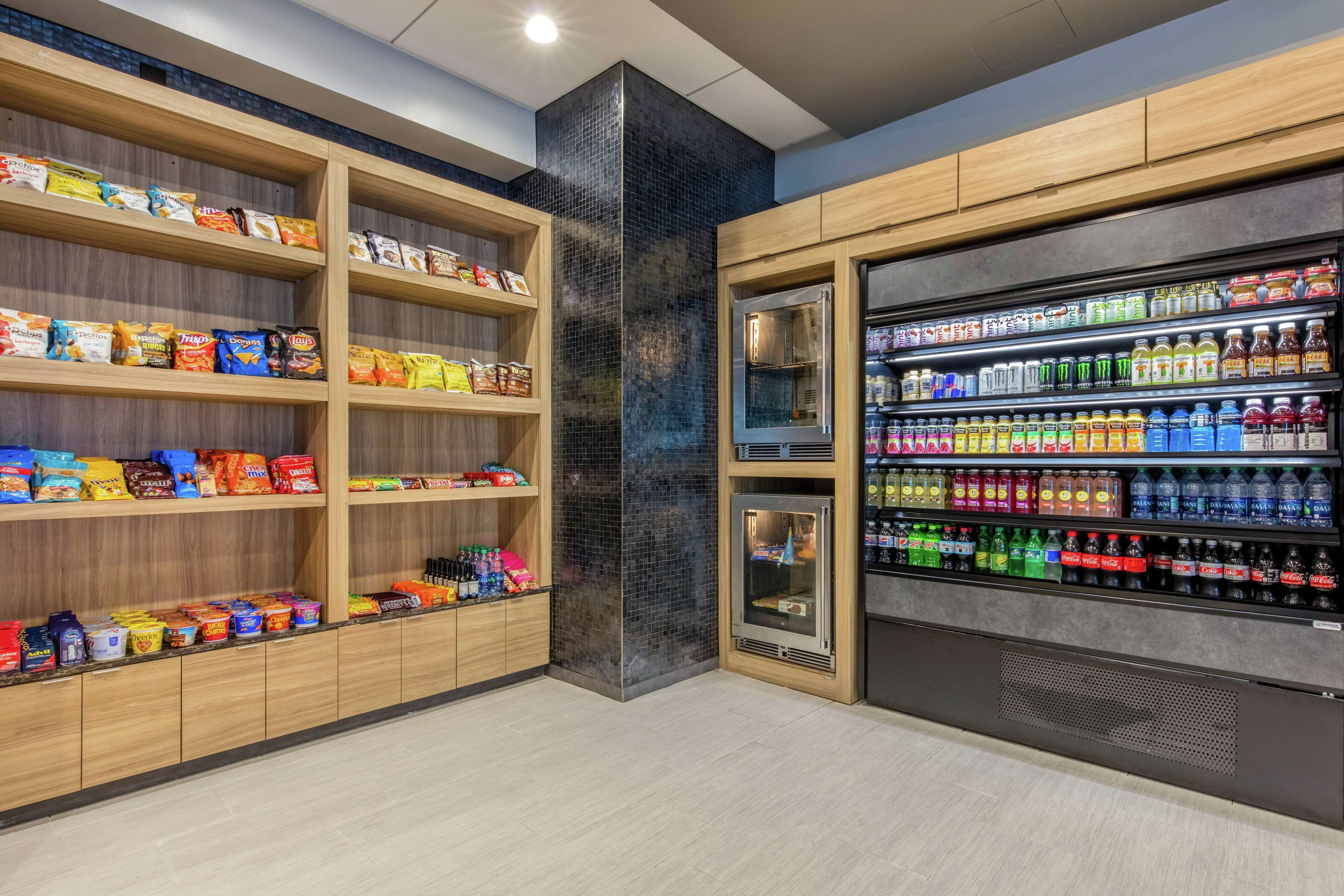 A snack and beverage kiosk with shelves of snacks and a refrigerated section with various drinks.