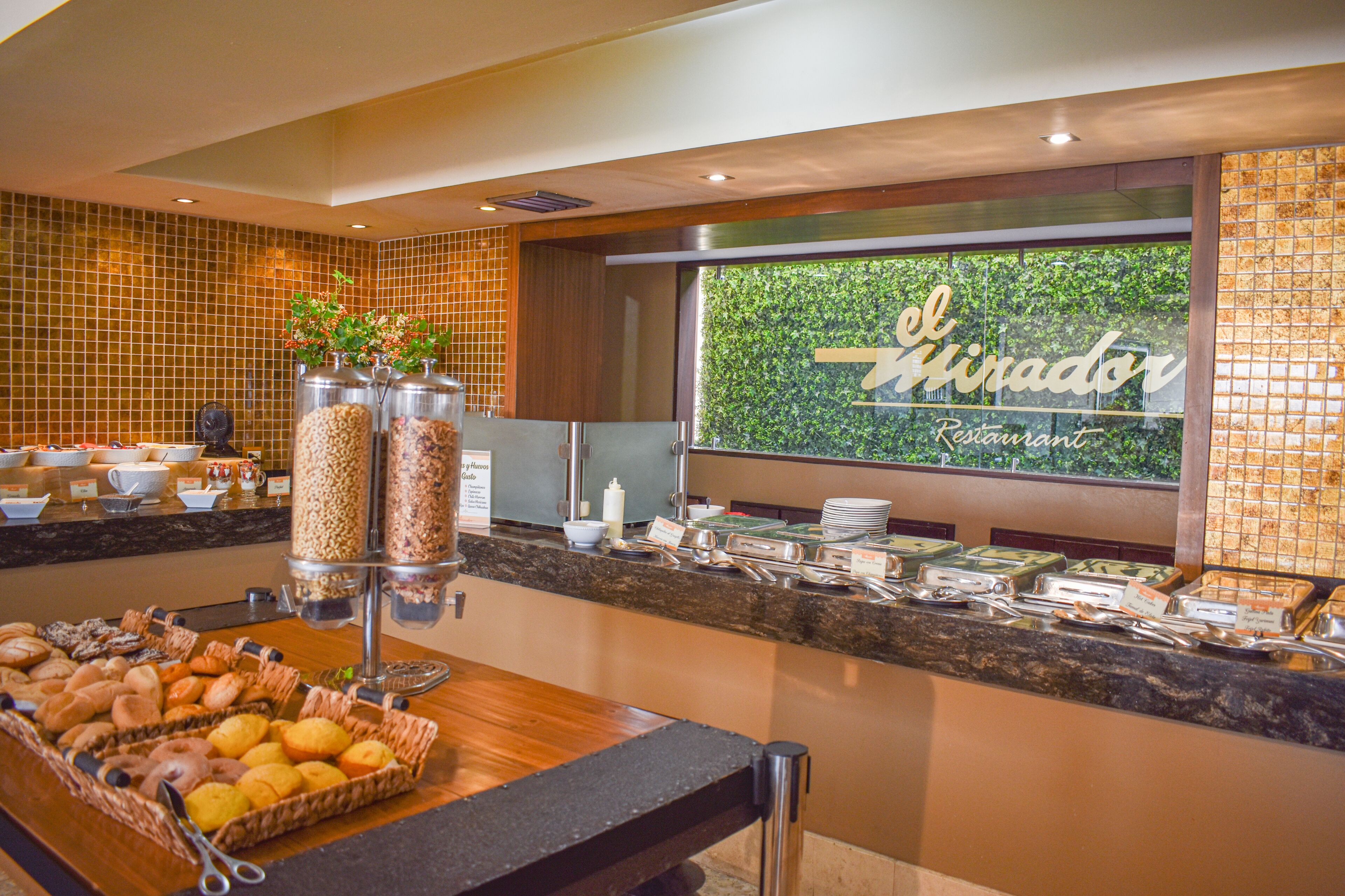 A buffet setup with various food items and a sign reading "El Mirador Restaurant".