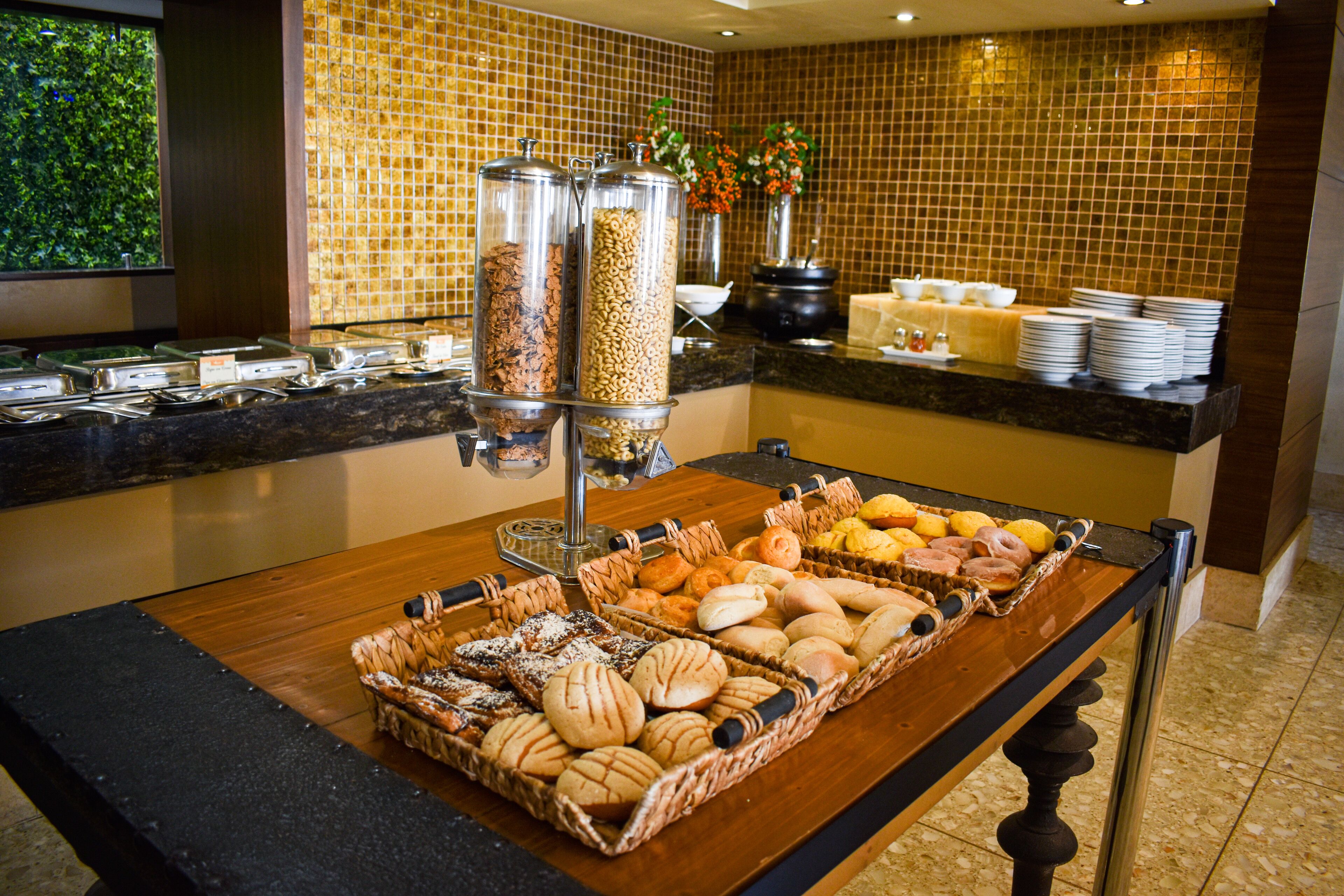 Buffet com diversos pães e uma estação de café.