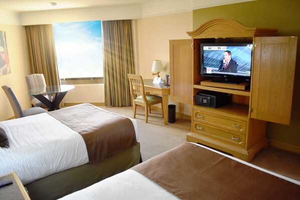 A hotel room with two beds, a desk with a chair, a television, and a cabinet. - Hotel San Luis Lindavista (Culiacán)