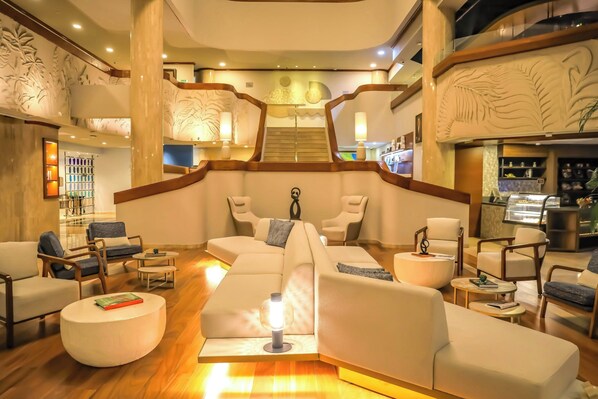 A modern lobby with a central seating area, wooden accents, and a staircase. - Delta Hotels by Marriott San Jose Aurola (San José)