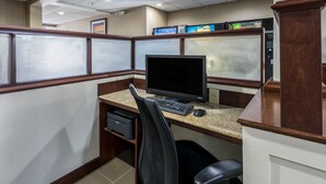 Un petit bureau avec un ordinateur, une chaise et un bureau.