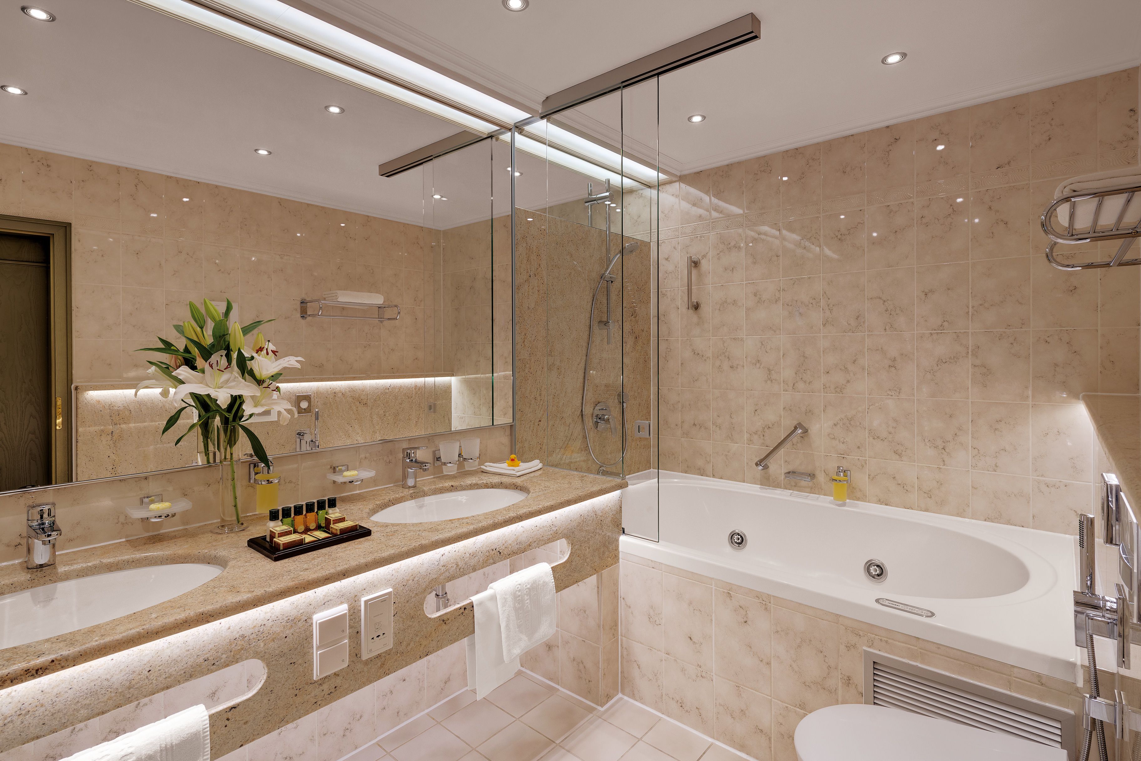 Une salle de bain moderne avec deux lavabos, une grande baignoire et une douche à l’italienne.