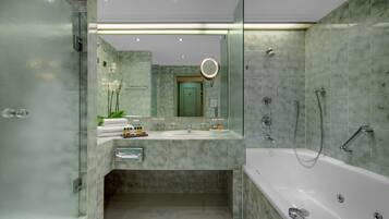 A modern bathroom with a glass-enclosed shower, a large bathtub, and a vanity with a mirror.