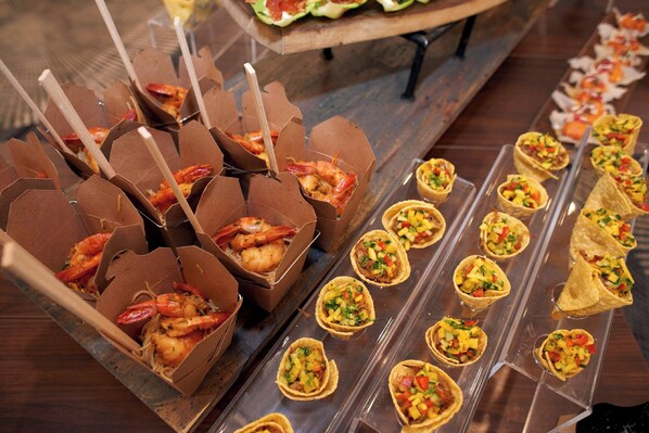 A buffet with shrimp and taco appetizers.