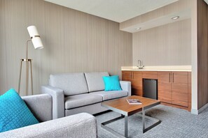 A modern living room with a grey sofa, a wooden coffee table, and a floor lamp.