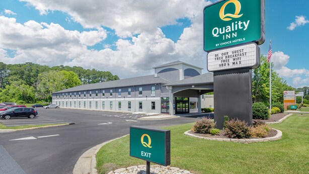 A Quality Inn by Choice Hotels with a clear sky and a parking lot in front.