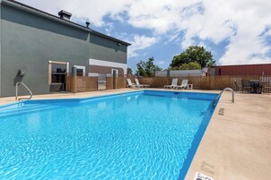 Una piscina al aire libre, sillones reclinables de piscina