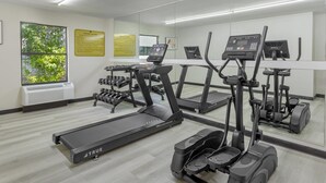 A fitness center with treadmills, elliptical machines, and dumbbells. - Quality Inn Washington NC (Washington)