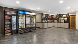 A modern hotel lobby with a vending machine, a refrigerator, and a counter with a marble backsplash. - Quality Inn Washington NC (Washington)