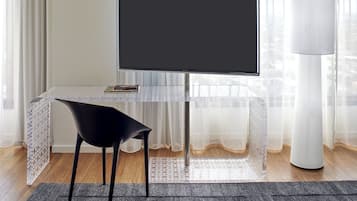 A room with a clear view of a large window, a black chair, a table with a white tablecloth, and a blackboard.