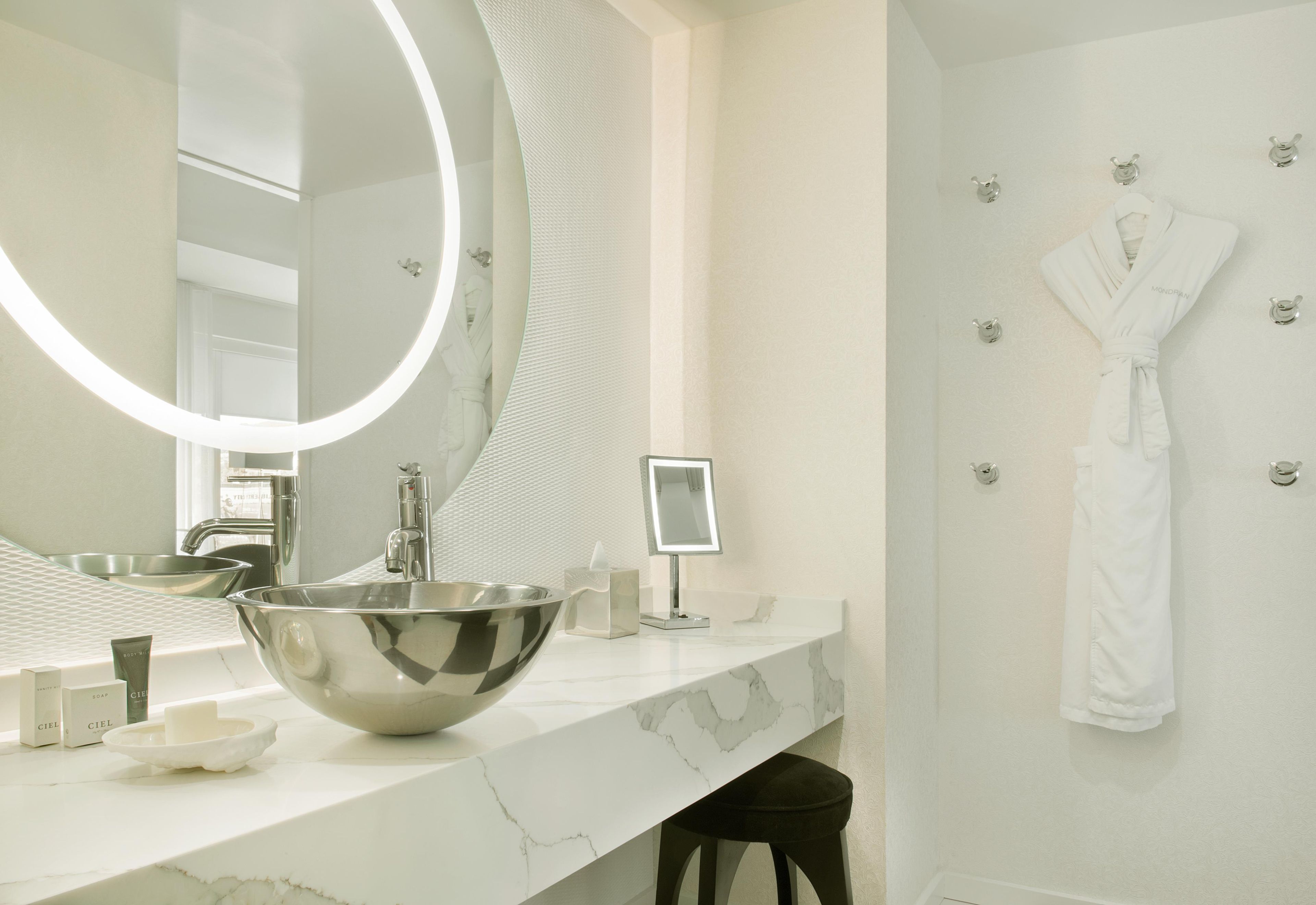Un baño moderno con un espejo grande, un lavabo y un perchero para toallas.