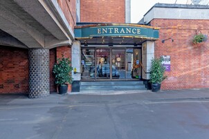 Un edificio de ladrillo con un toldo verde que dice 'ENTRANCE'.