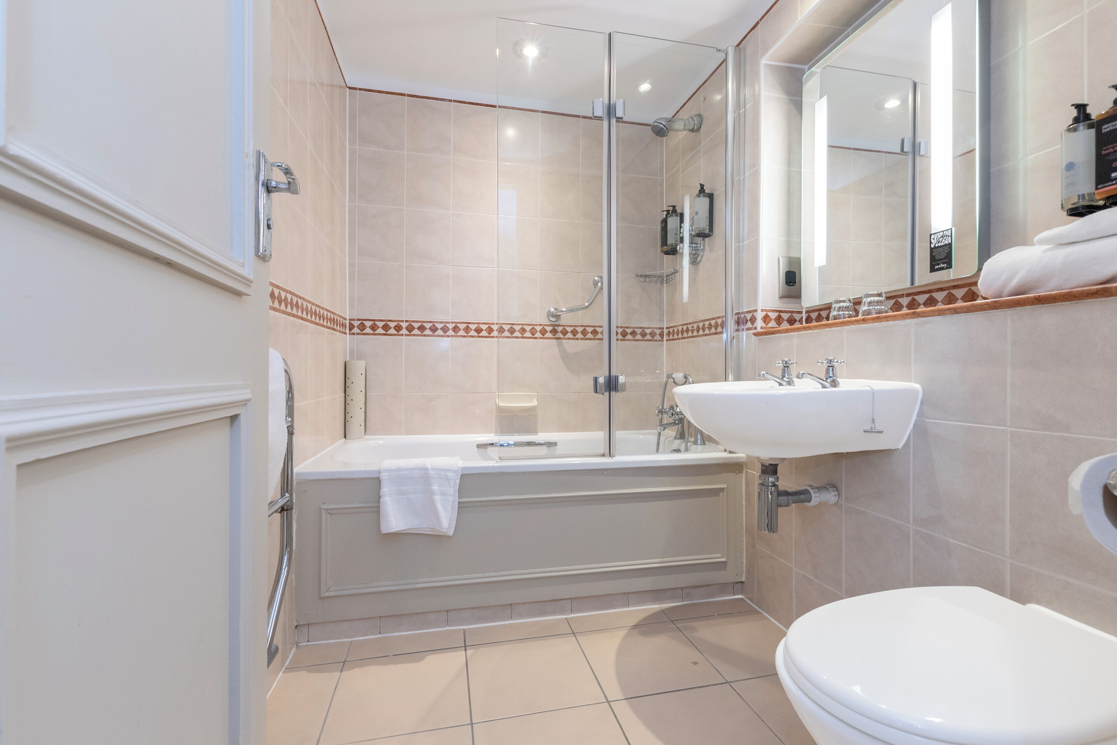 A modern bathroom with a bathtub, a sink, and a toilet.