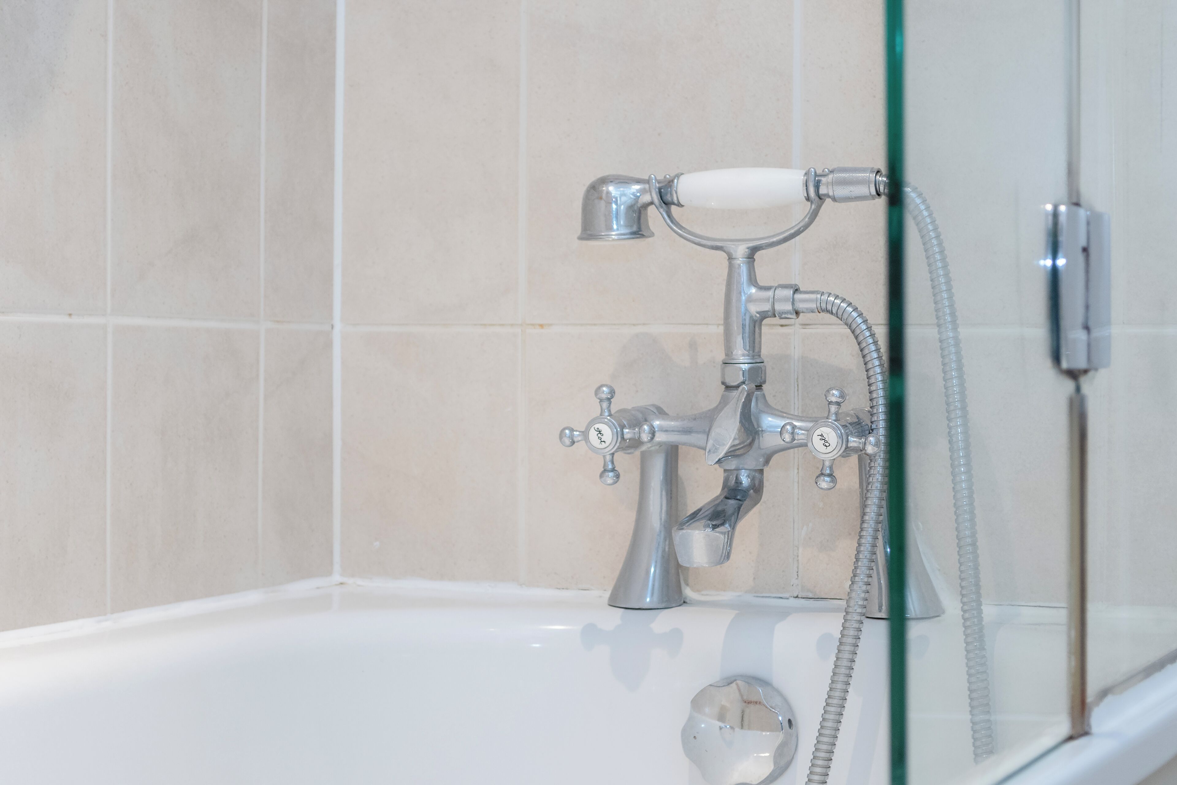 A bathroom with a bathtub, a shower, and a glass-enclosed shower area.