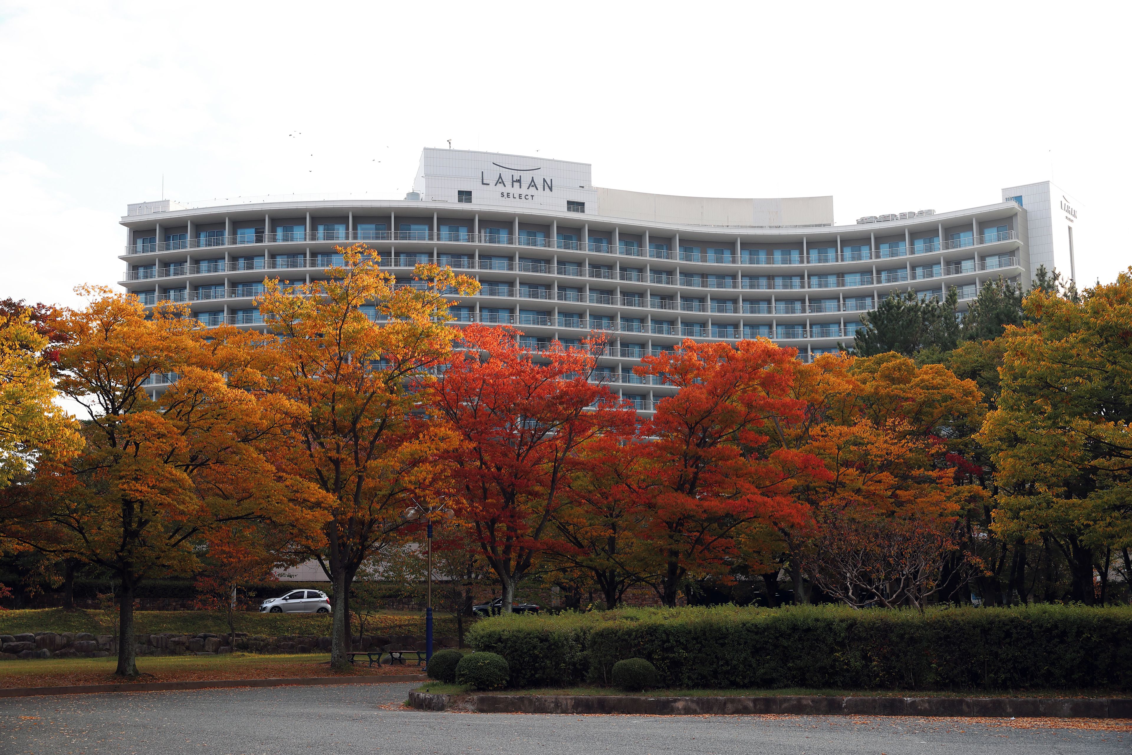 A multi-story building with a modern architectural design, featuring a curved facade and a series of balconies.