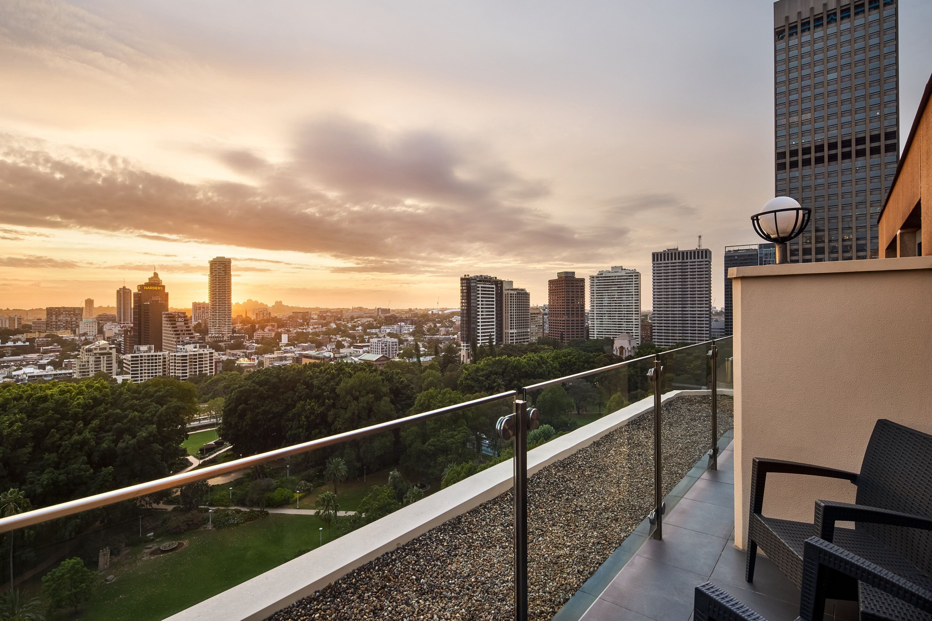 A balcony with a city view, a lamp post, and a chair.
