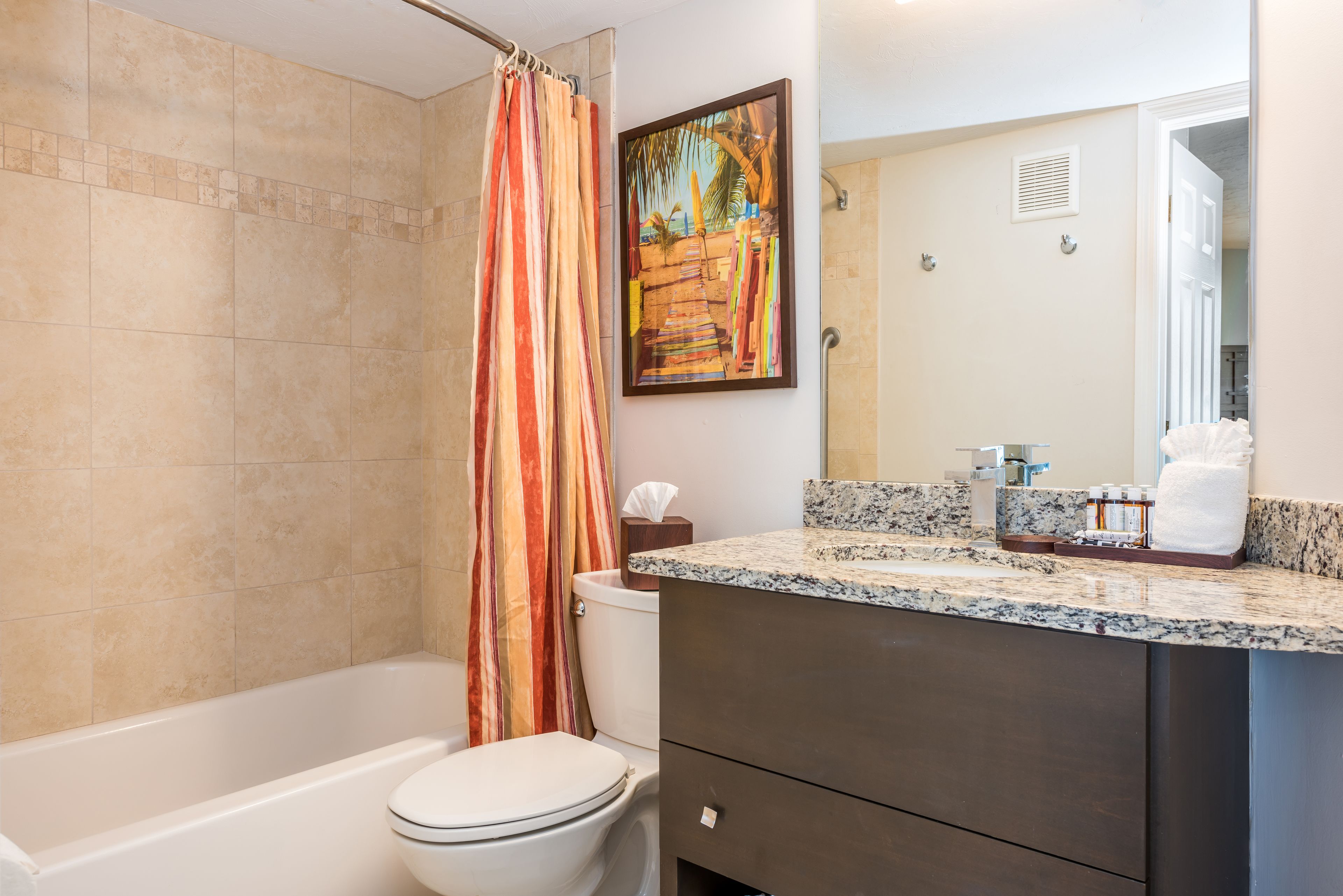 A bathroom with a bathtub, toilet, and shower curtain.