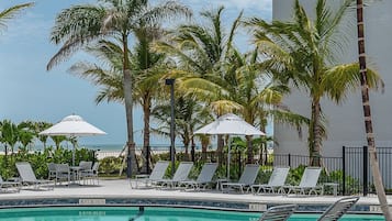 Een buitenzwembad, parasols voor strand/zwembad