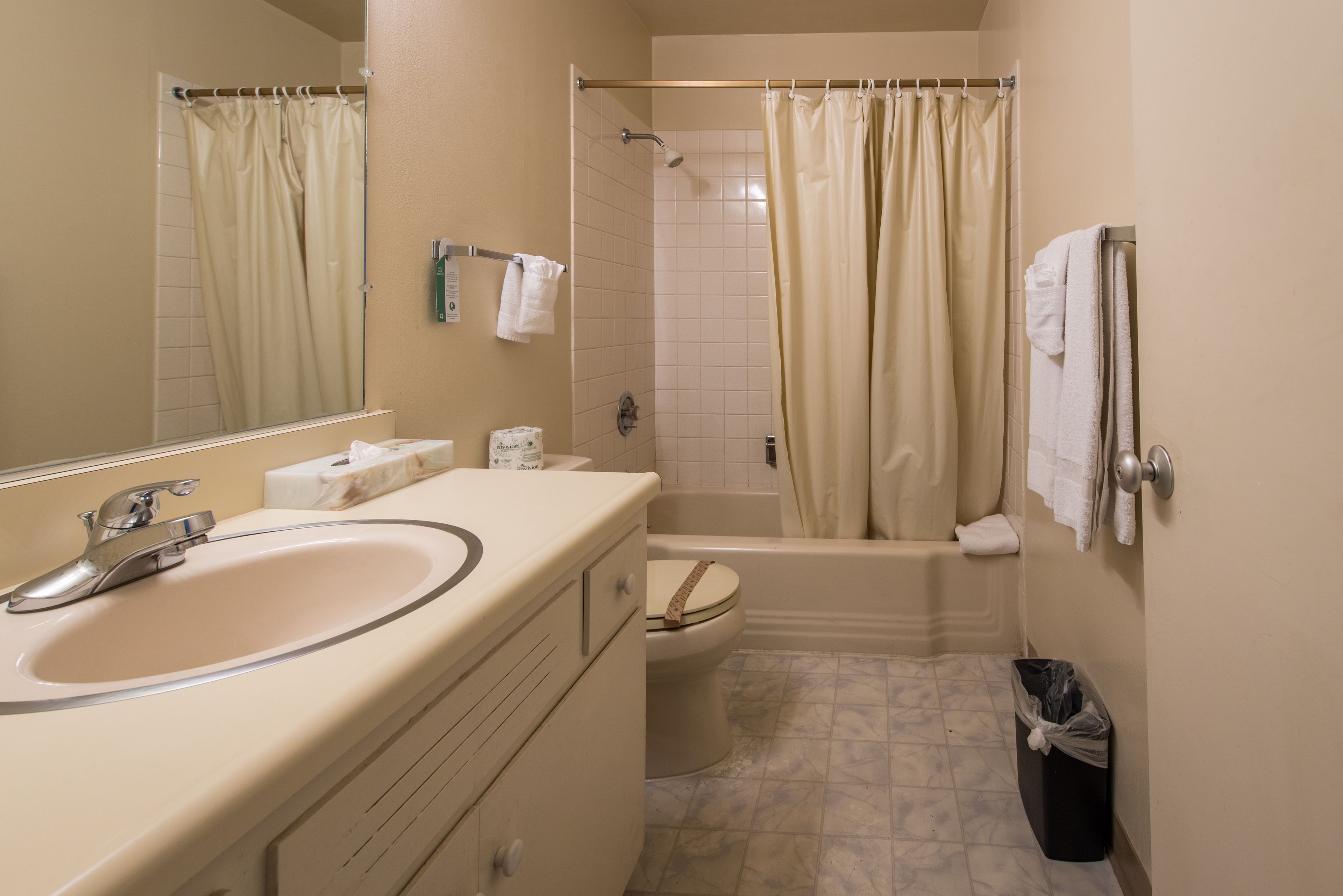 Un baño con lavamanos, inodoro, bañera y cortina de ducha.